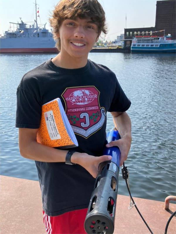 Conor Gabel holds a YSI next to Muskegon Lake